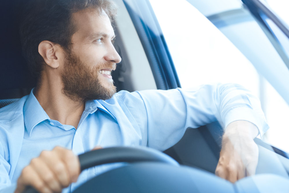 Man making cash with his car driving and looking out window
